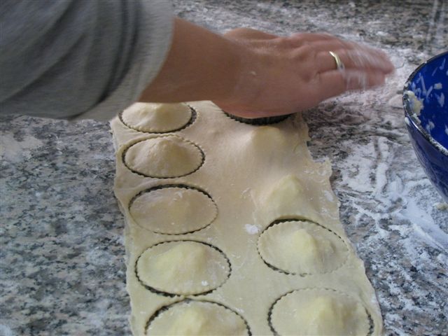 חיתוך ועיצוב צורת הבצק כחלק מתהליך הכנת הקלצונה